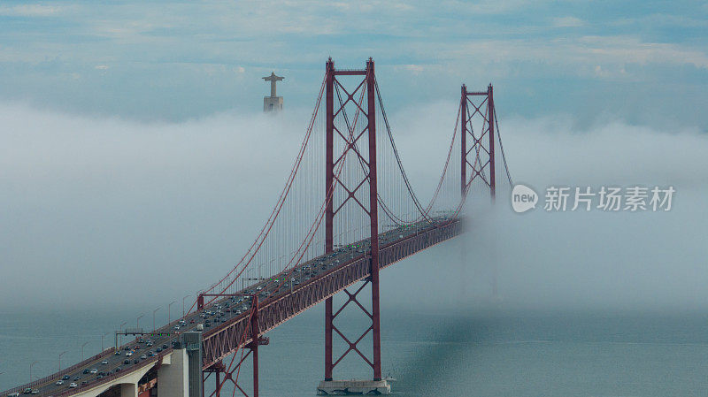 鸟瞰图25 de Abril桥，里斯本，覆盖在雾中，从一边到另一边的交通工具